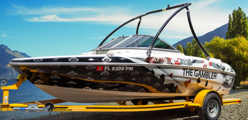 A boat named 'The Gambler' featuring a custom wrap design and mounted on a trailer.