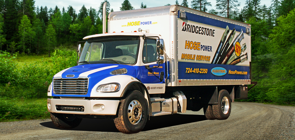 Blue and silver mobile service truck with Bridgestone Hose Power branding parked on a dirt road.