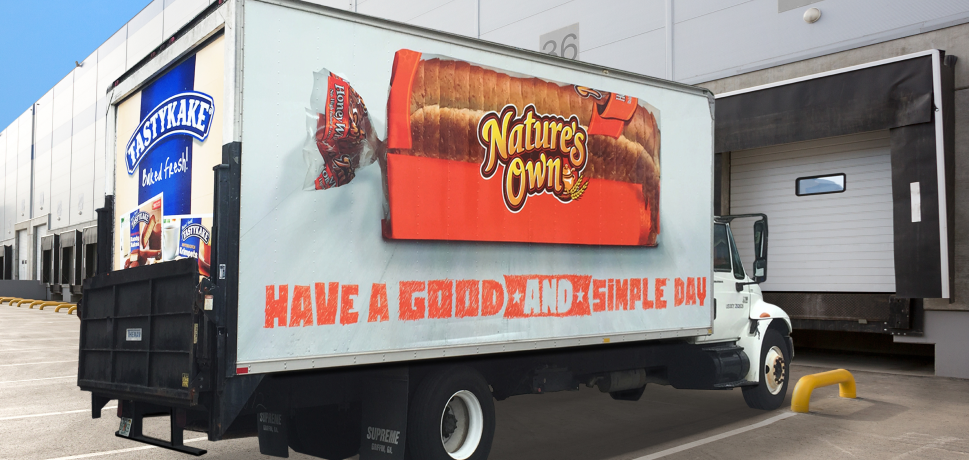Delivery truck featuring Nature's Own bread packaging on its side with a slogan.
