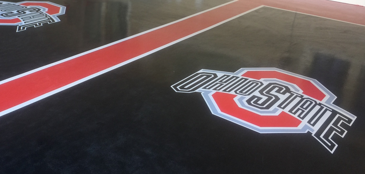 Ohio State University logo displayed on a black floor with a red stripe.