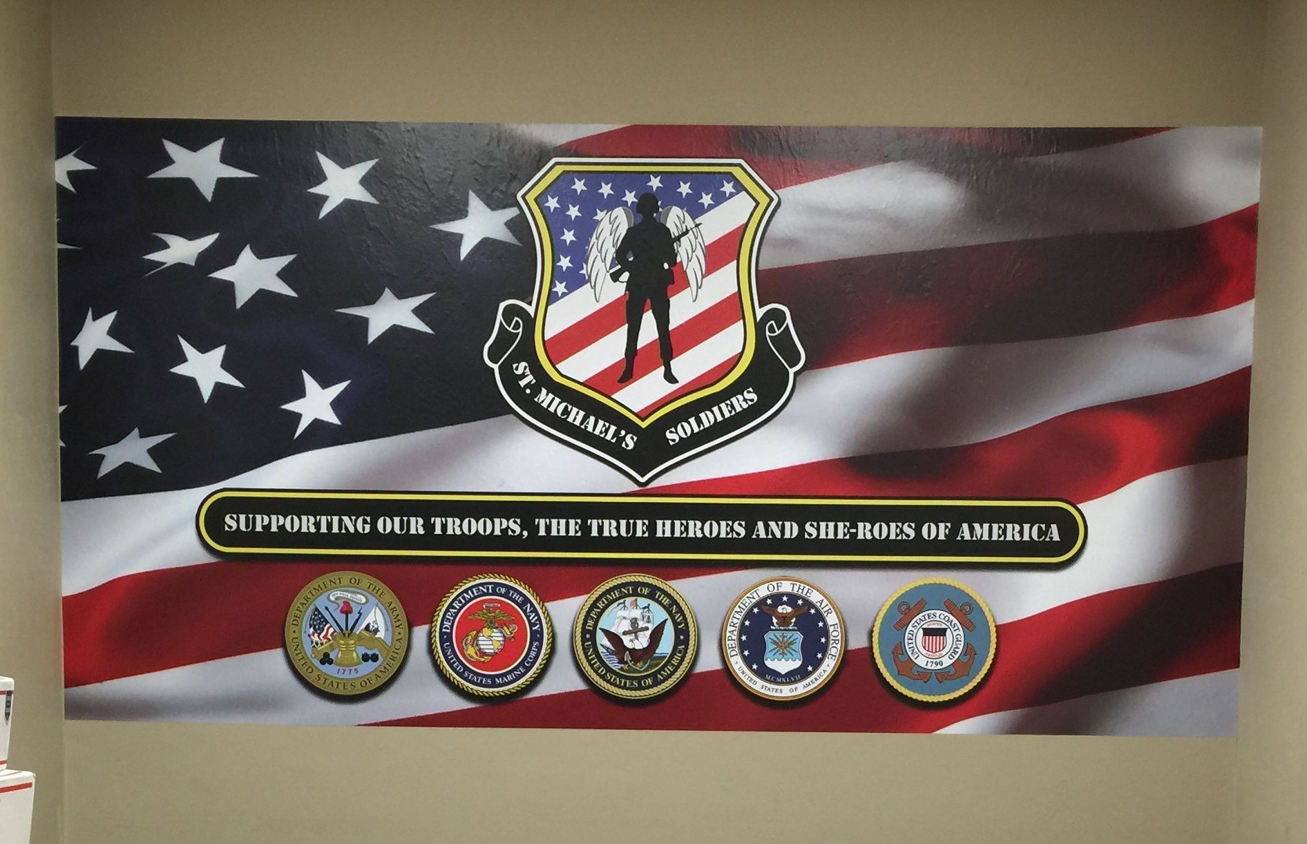 Interior custom American flag and United States of America military-themed vinyl wall wrap depicted on the inside wall of a home office building.