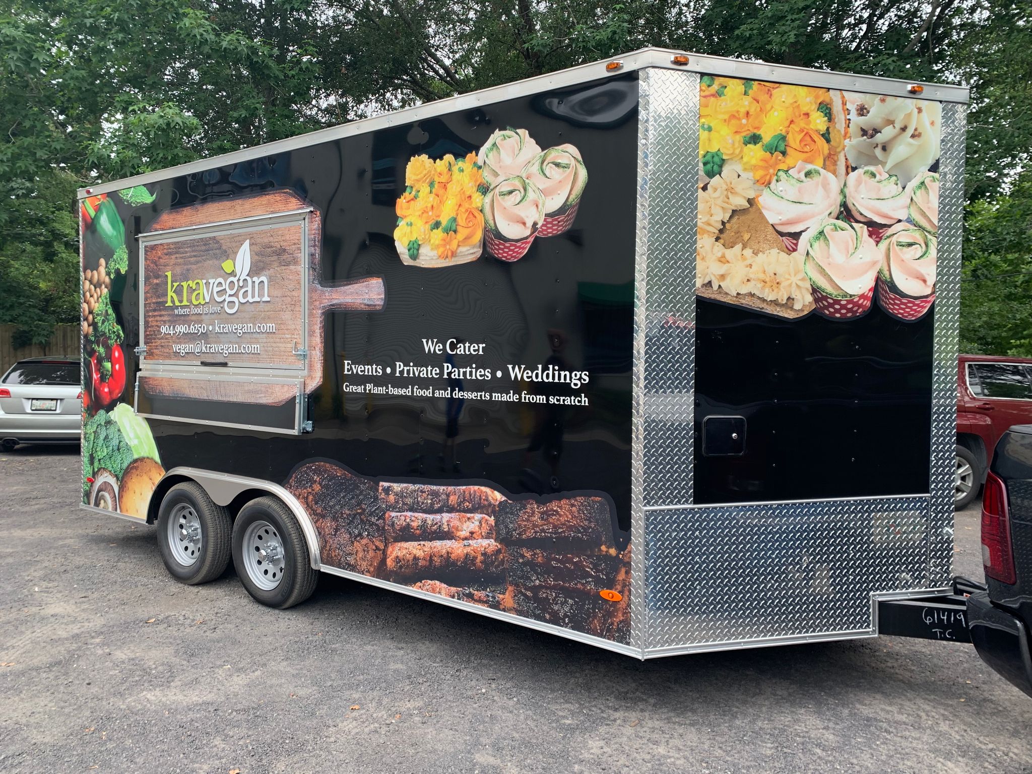 Large commercial two-wheel vegan food truck trailer, wrapped in a custom print glossy black vinyl trailer wrap. Personalized "KraVegan" food truck trailer wrap design, installed by Wraps Direct.