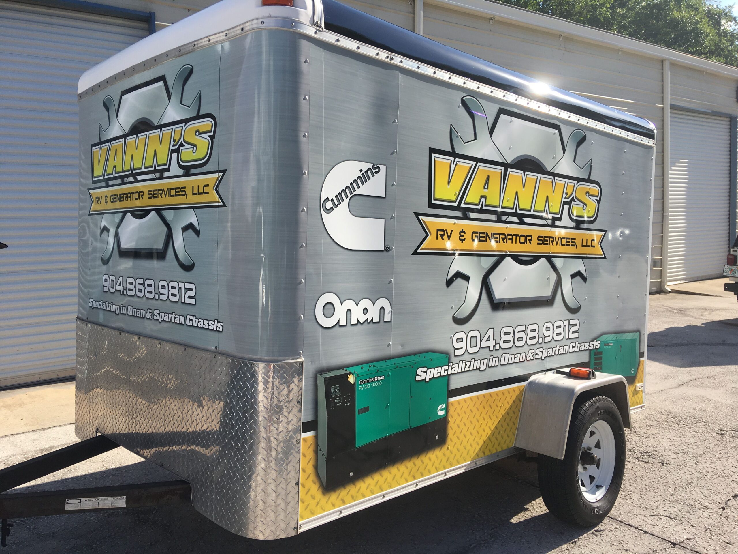 Small commercial one-wheel generator trailer, wrapped in a customized grey, yellow, and green glossy vinyl trailer wrap. Customized generator trailer wrap for "Vann's" wrapped by Wraps Direct in Jacksonville Florida.